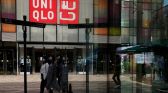 Women walk past a store of the Fast Retailing's fashion chain Uniqlo, in Beijing