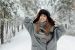 Smiling Woman Standing Beside Trees Covered by Snow