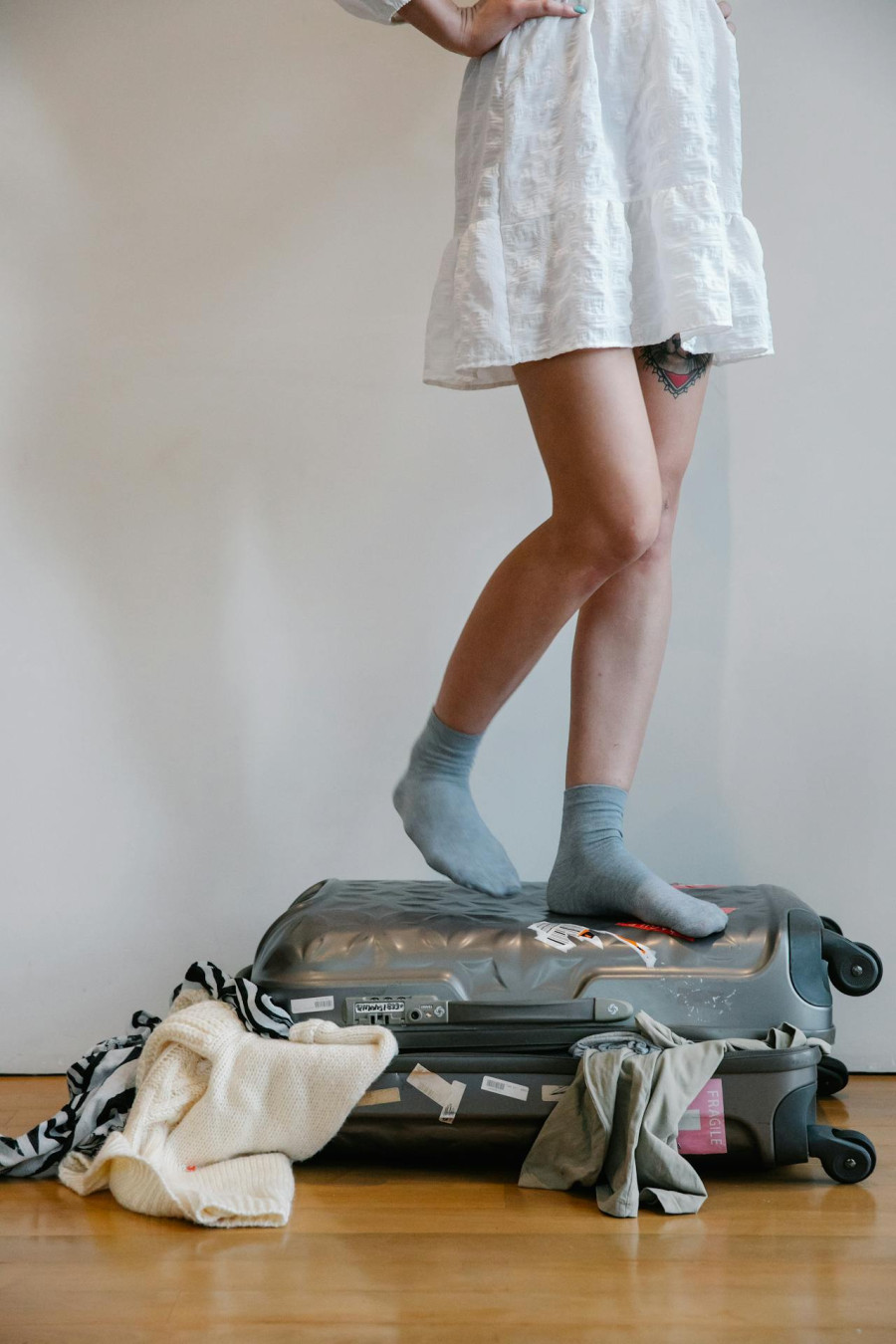 Woman Standing on Suitcase