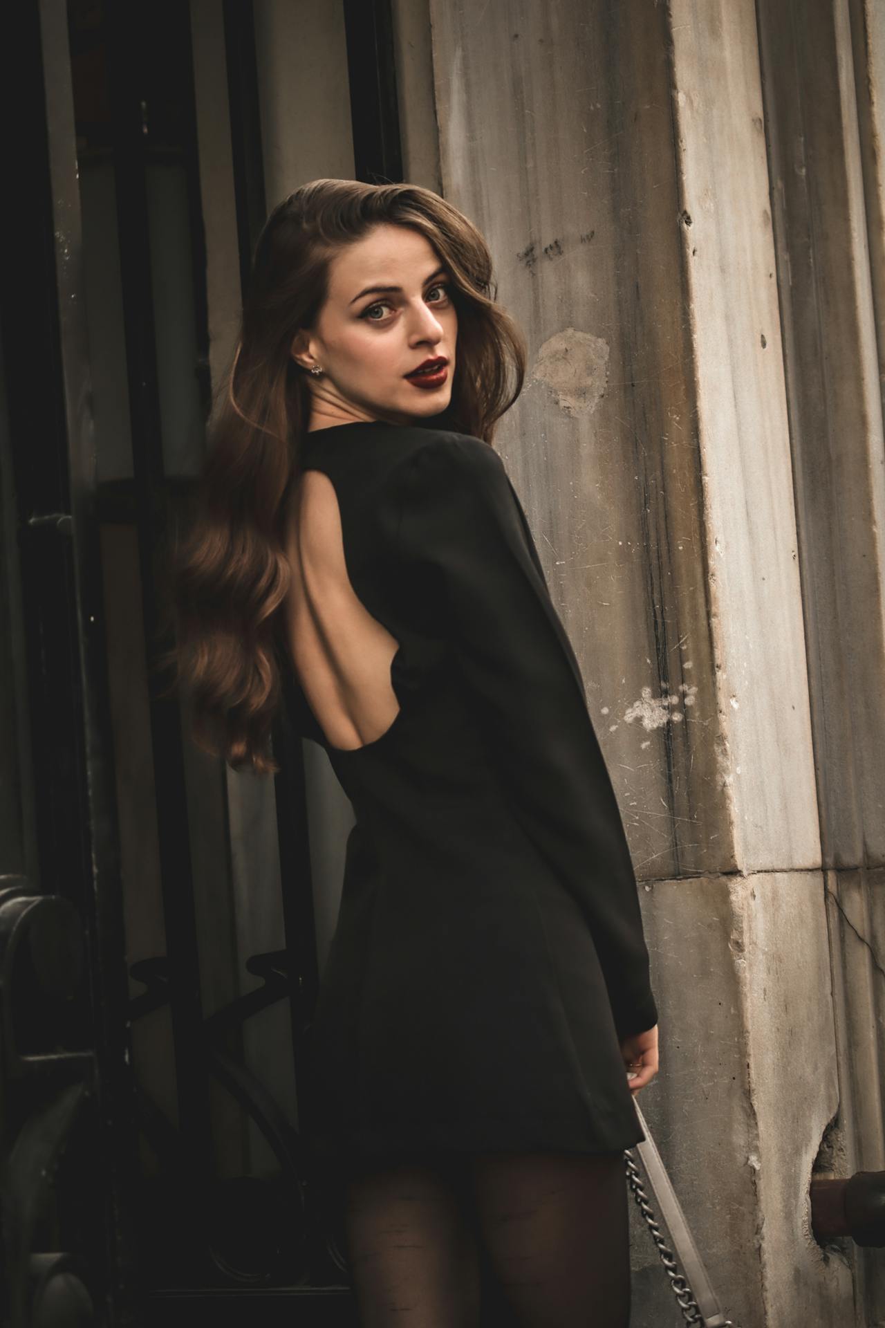 Elegant Woman in Black Dress Posing Outdoors