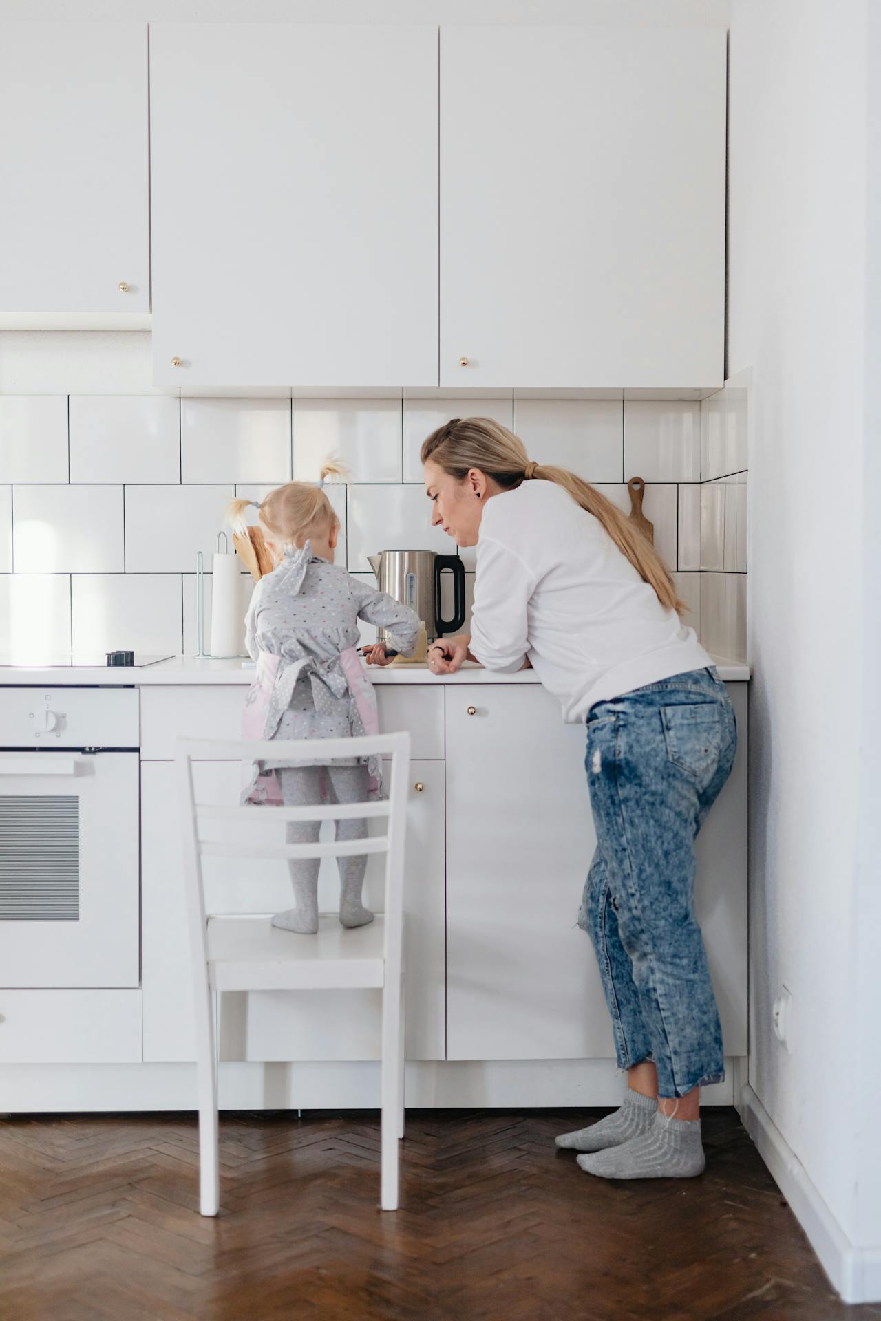 Mother and Daughter Standing on a Chair Preparing Food in 