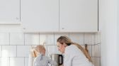 Mother and Daughter Standing on a Chair Preparing Food in