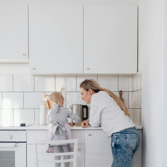 Mother and Daughter Standing on a Chair Preparing Food in