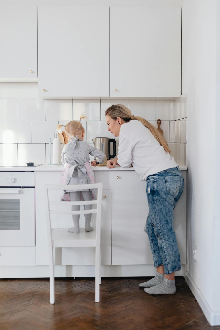 Mother and Daughter Standing on a Chair Preparing Food in
