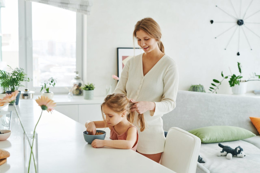 A Woman Braiding the Hair of a Young Girl