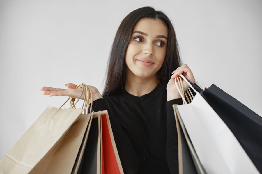 Woman in Black Long Sleeve Shirt Carrying Paper Bags