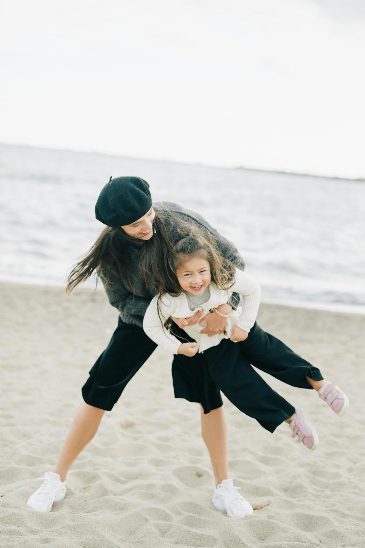 Photo of a Mother Carrying Her Child at the Beach