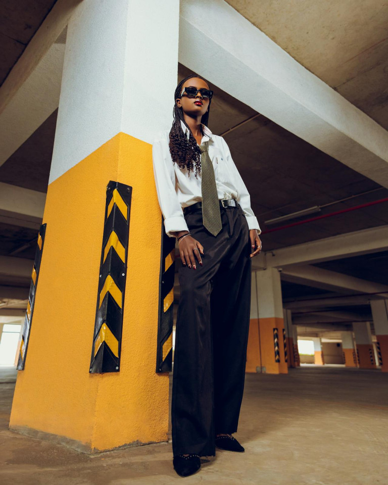 Woman posing by a garage